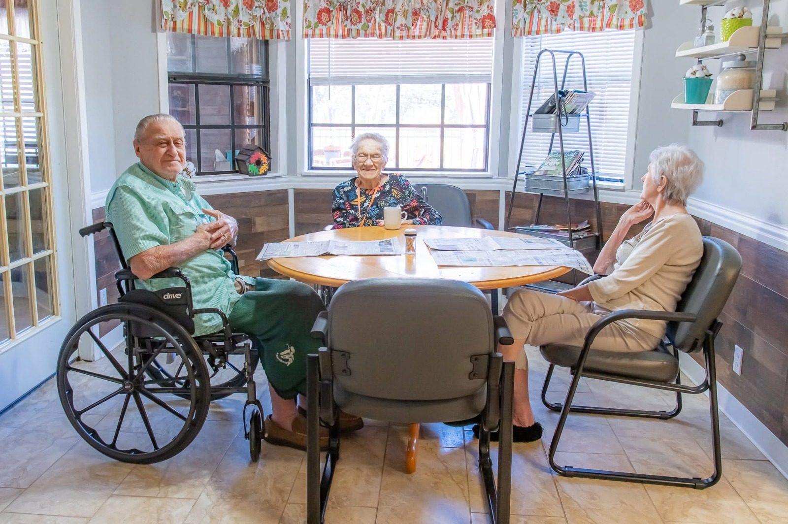 Residents visiting together at a sunroom table